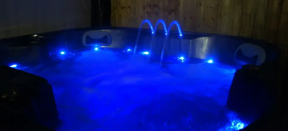 Hot tub at night lit up in blue at Mill Farm Leisure