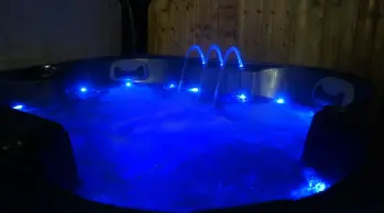 Hot tub at night lit up in blue at Mill Farm Leisure